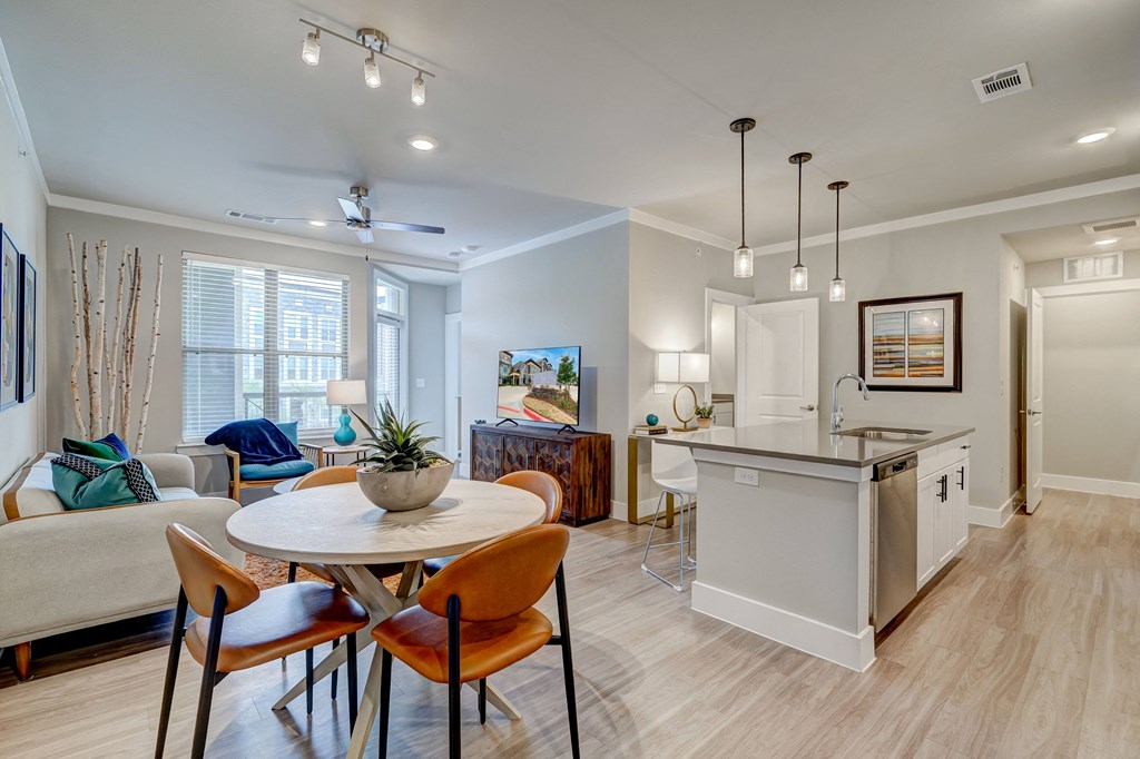 an open living room and kitchen with a table and chairs