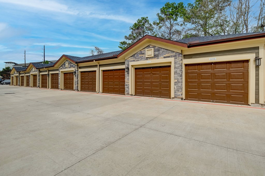 a row of garage doors in front of a parking lot