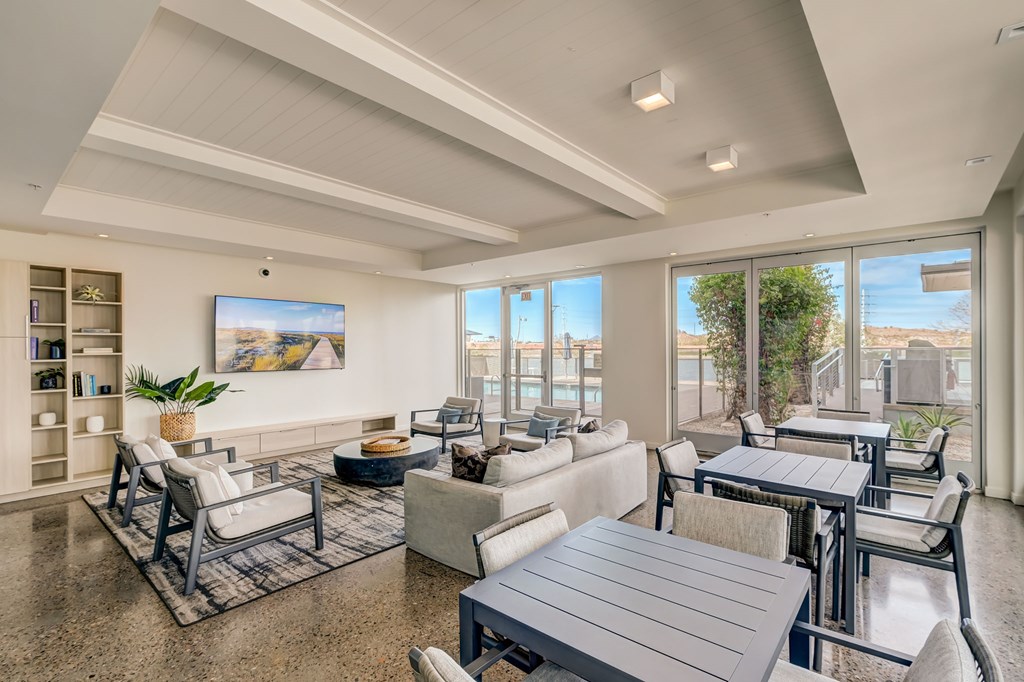 A spacious living room with a large window overlooking a balcony.