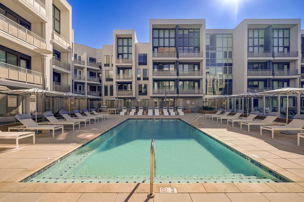 A large swimming pool in front of apartment buildings.