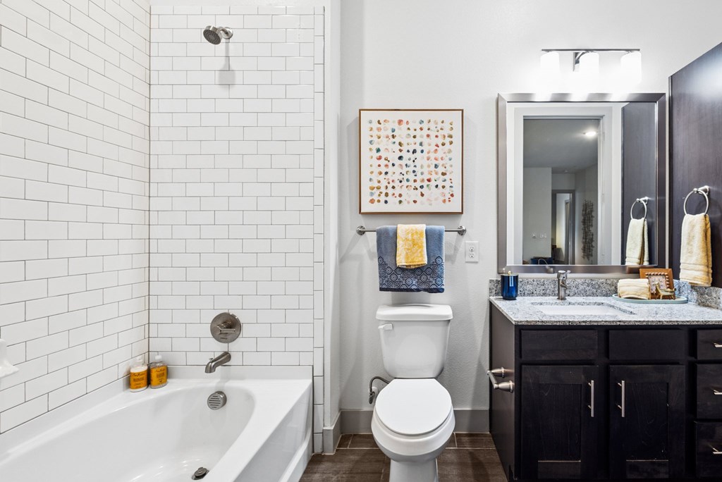 A bathroom with a white tub, toilet, and sink.
