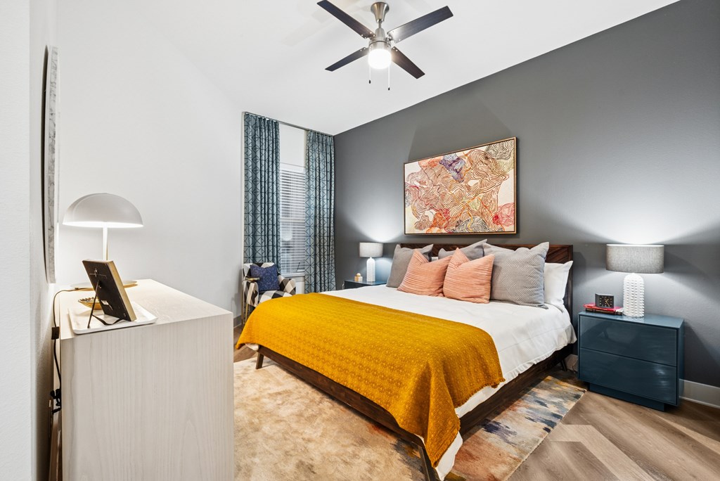 A bedroom with a bed, nightstand, and lamp.