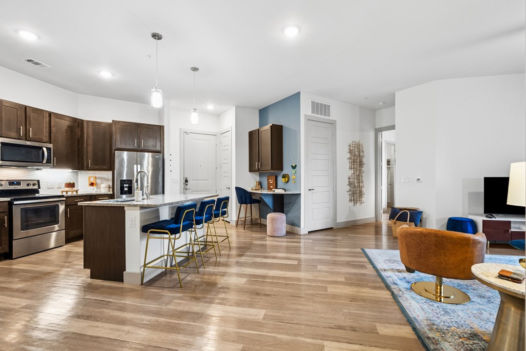 A modern kitchen with a dining area and a living room.
