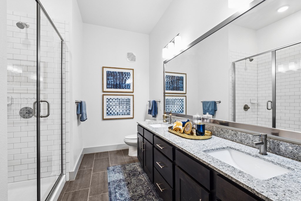 A bathroom with a walk-in shower, a sink, and a mirror.