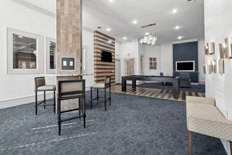 A living room with a grey carpet and a black couch.