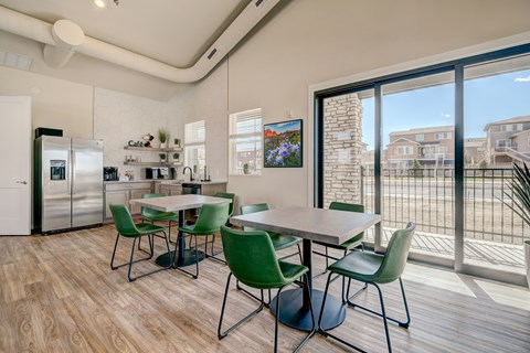 A kitchen with a dining table and chairs.