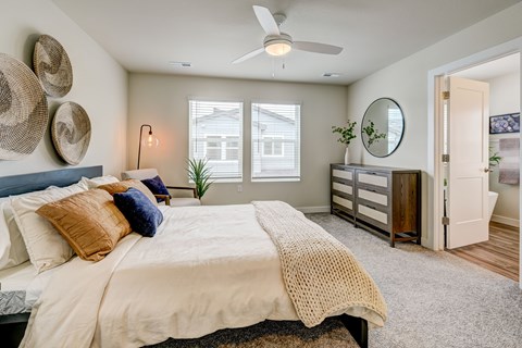 A bedroom with a large bed and a ceiling fan.
