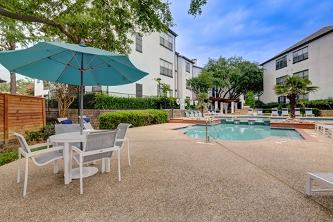 our apartments have a pool and patio with chairs and umbrellas