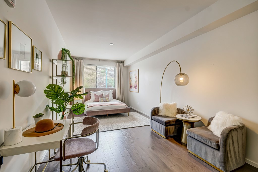 A well-lit, modern bedroom with a large bed and a comfortable seating area.