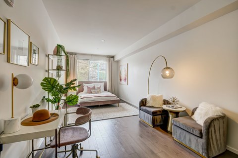 A well-lit, modern bedroom with a large bed and a comfortable seating area.