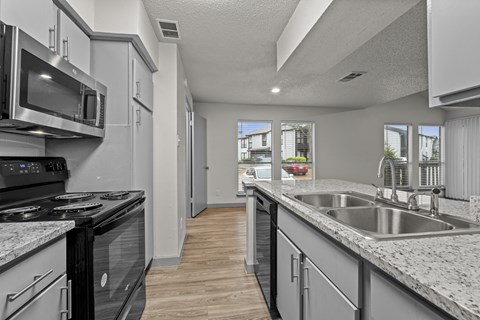 A kitchen with a black stove top oven and a black dishwasher.