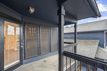 A balcony with a black railing and a glass door.