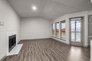 A room with a fireplace and sliding glass doors.