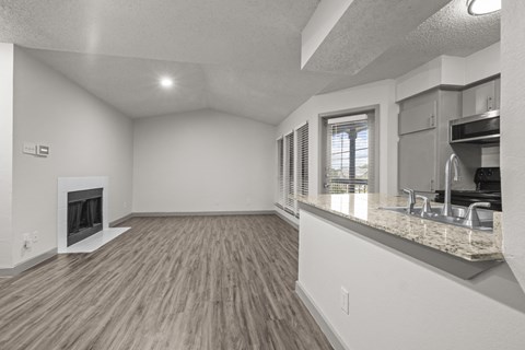 A spacious living room with a fireplace and hardwood floors.