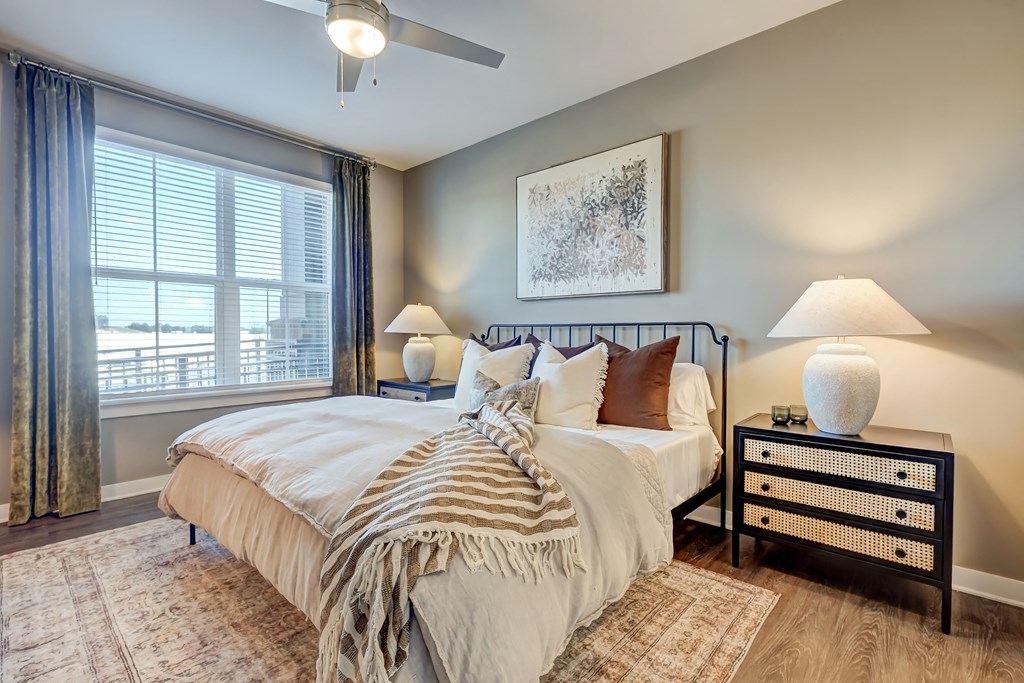 a bedroom with a large window and a bed