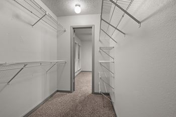 A white hallway with a carpeted floor and a light on.