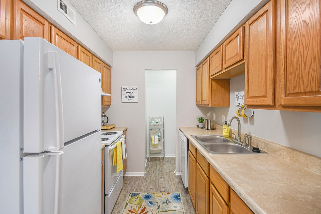 a kitchen with white appliances and wooden cabinets