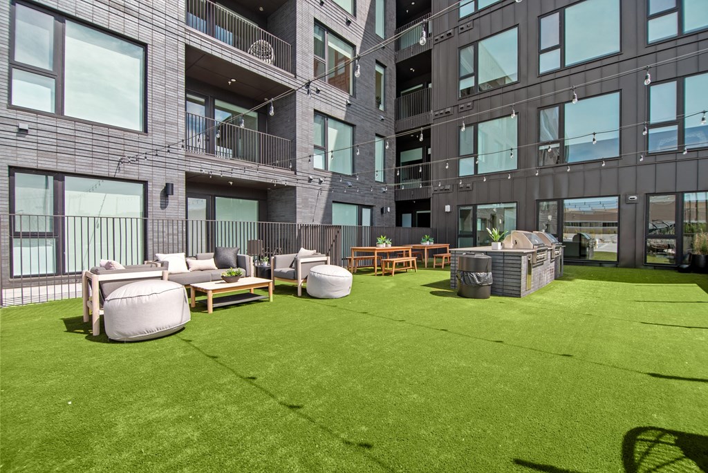 a large yard with furniture and chairs in front of a building