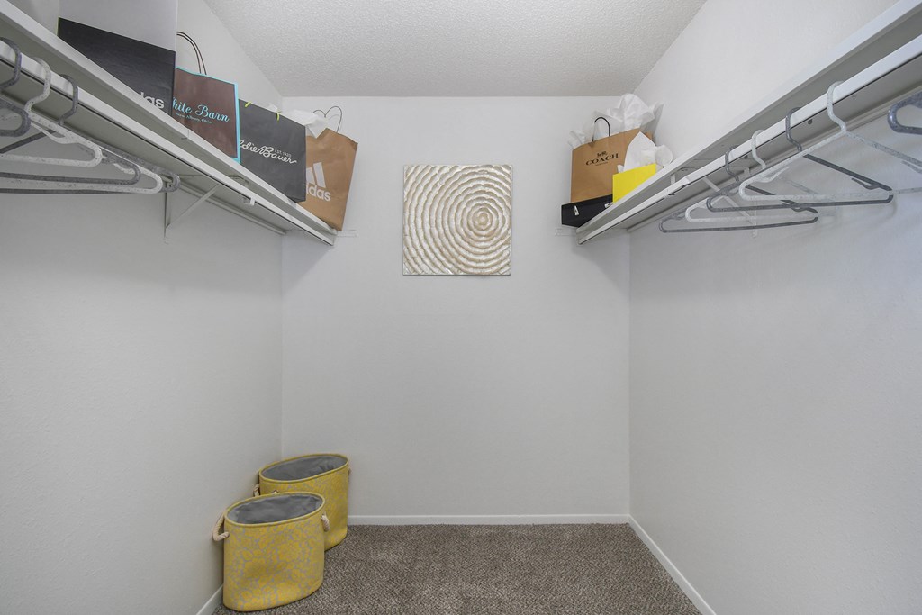 a closet with bins and shelves and a wall with boxes and a shelf on top