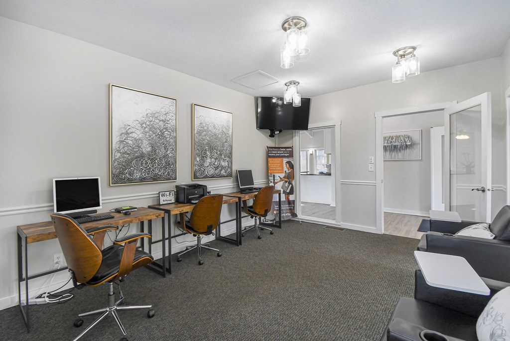 a conference room with desks and chairs and a television