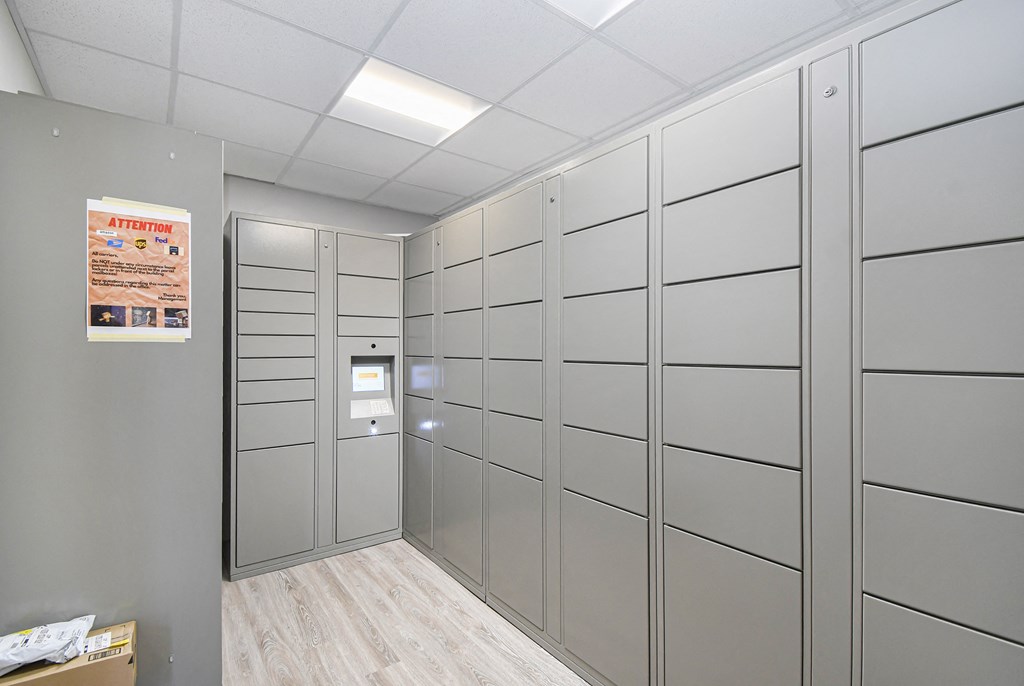 the walk in closet in this office has a lot of white cabinets and a door