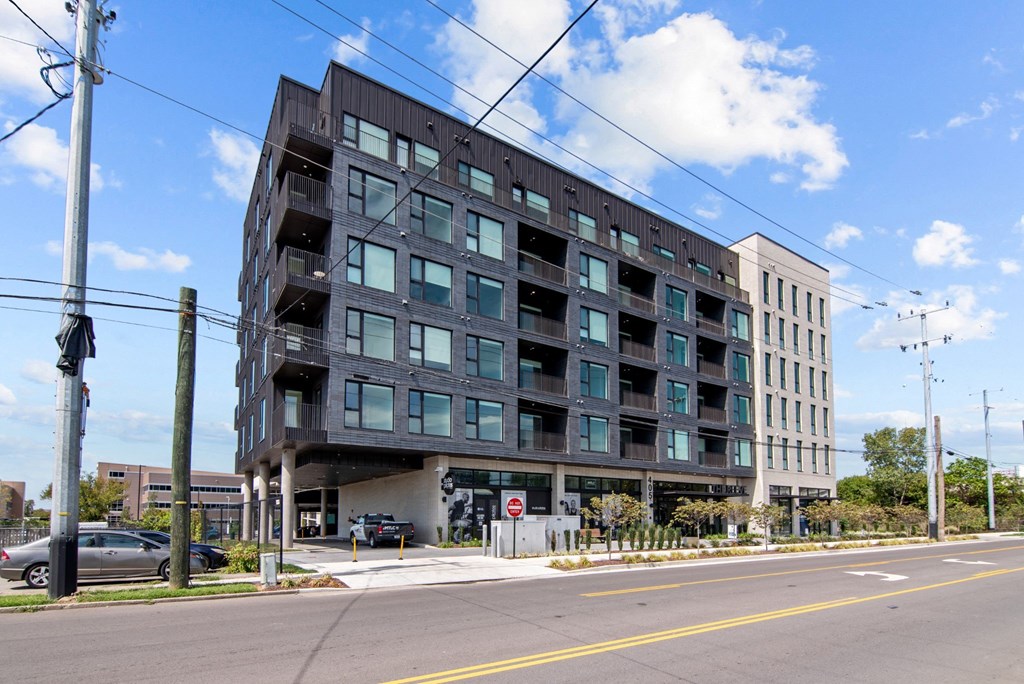 A modern building with a black facade and glass windows.