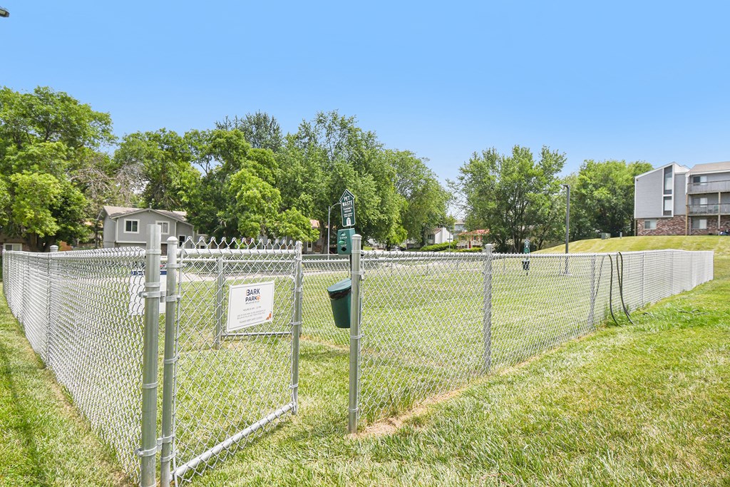 a chain link fence with apartments in the background