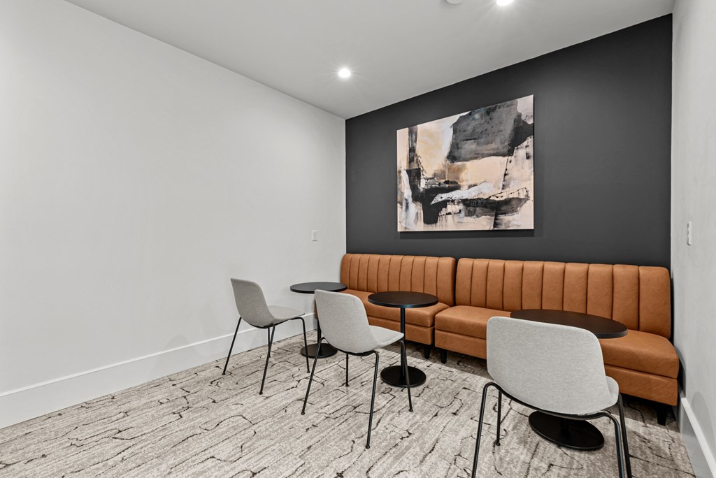 A room with a brown couch, a chair, and a table.