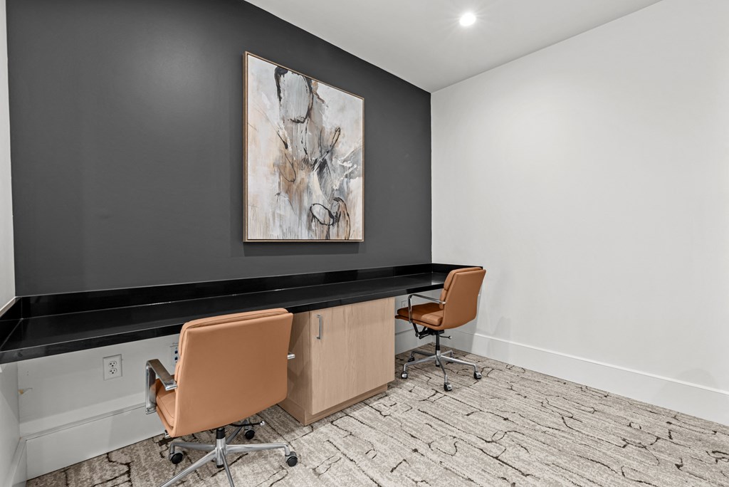 A room with a black countertop and two chairs.