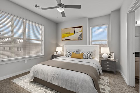 A bedroom with a large bed and a ceiling fan.