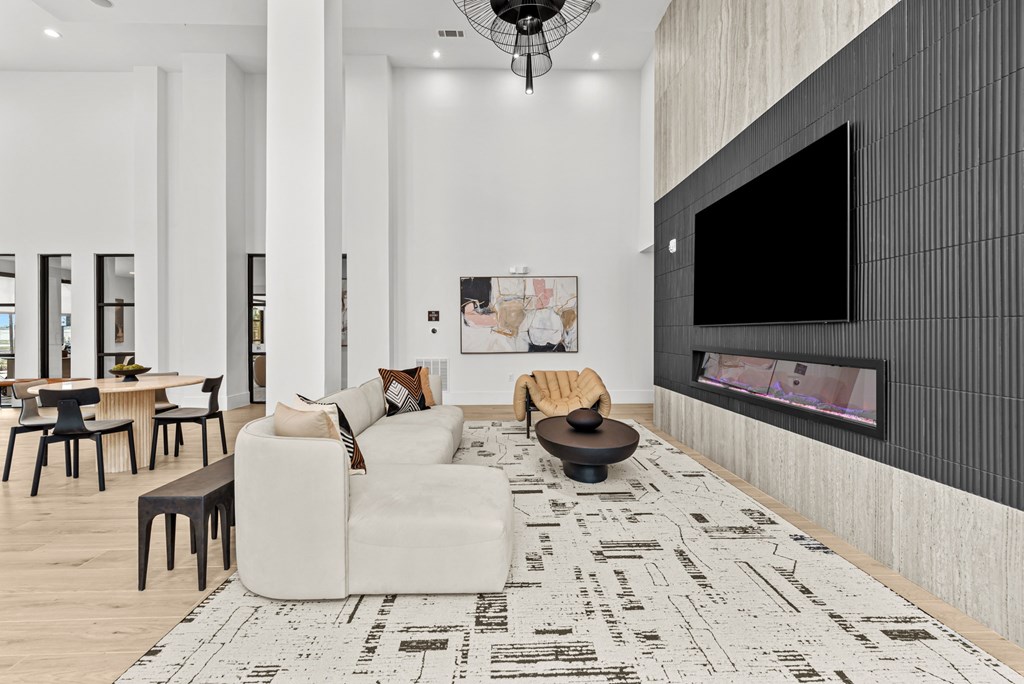 A modern living room with a large television and a patterned rug.