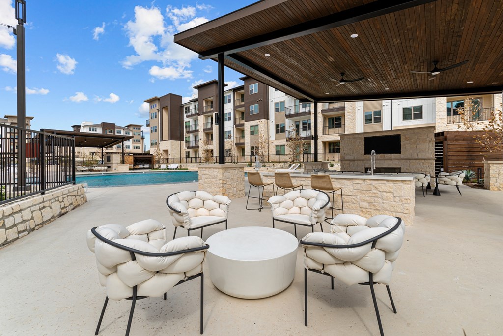 A patio with white chairs and a table.