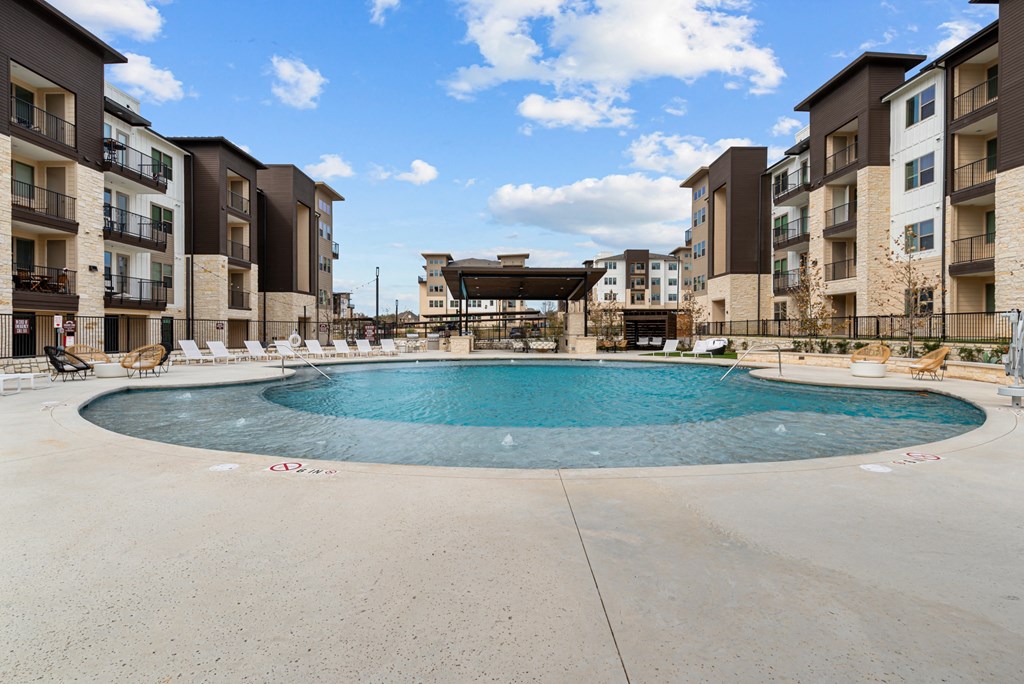 A large swimming pool in front of apartment buildings.