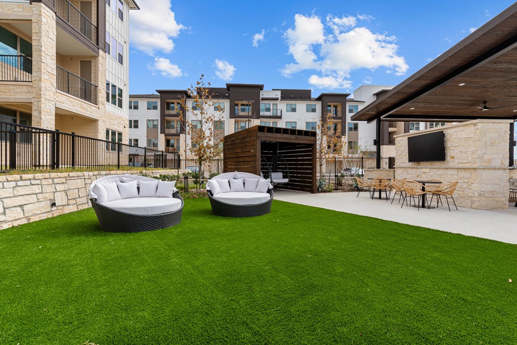 A backyard with two round seating areas and a patio.