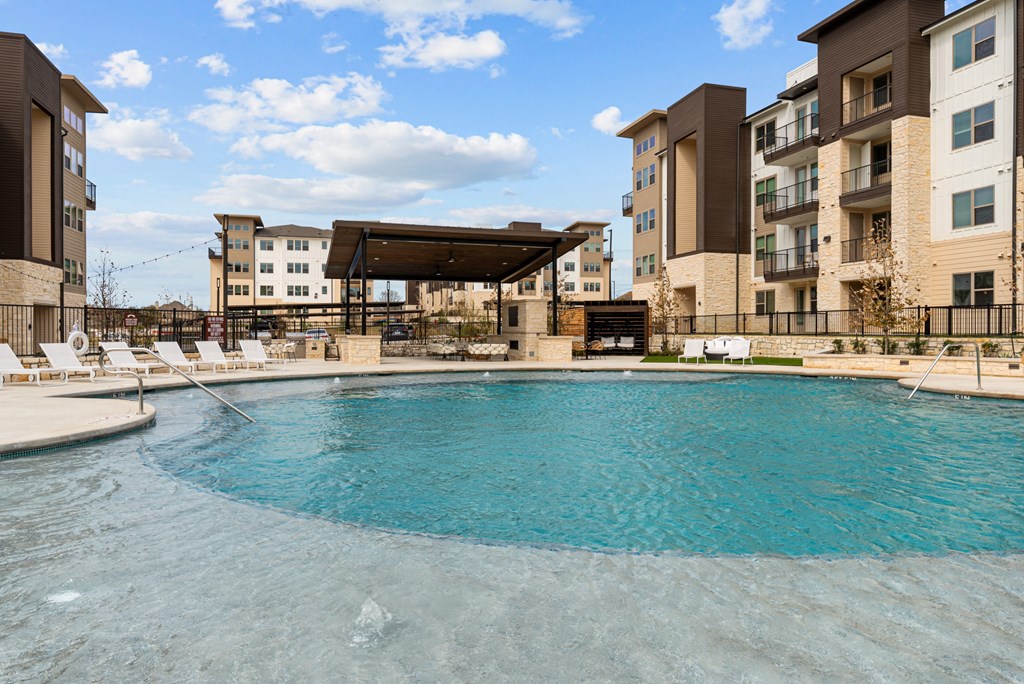 A large swimming pool in front of apartment buildings.