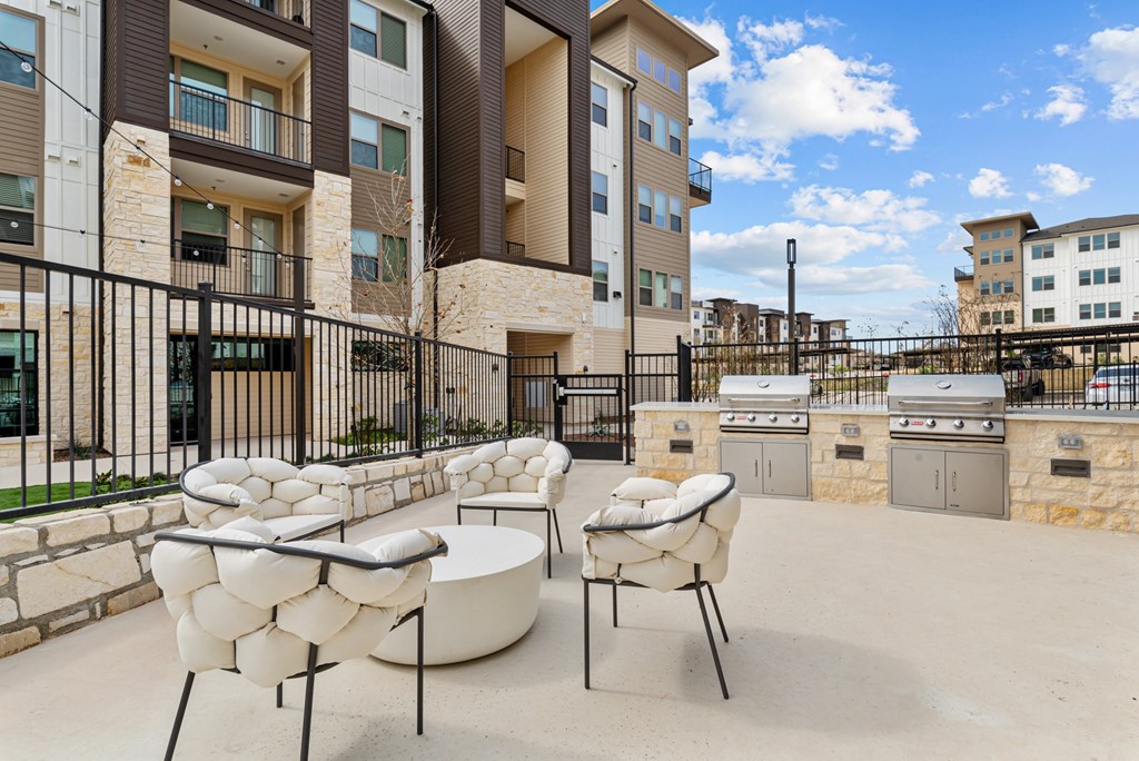 A patio with a white chair and table in front of a building.