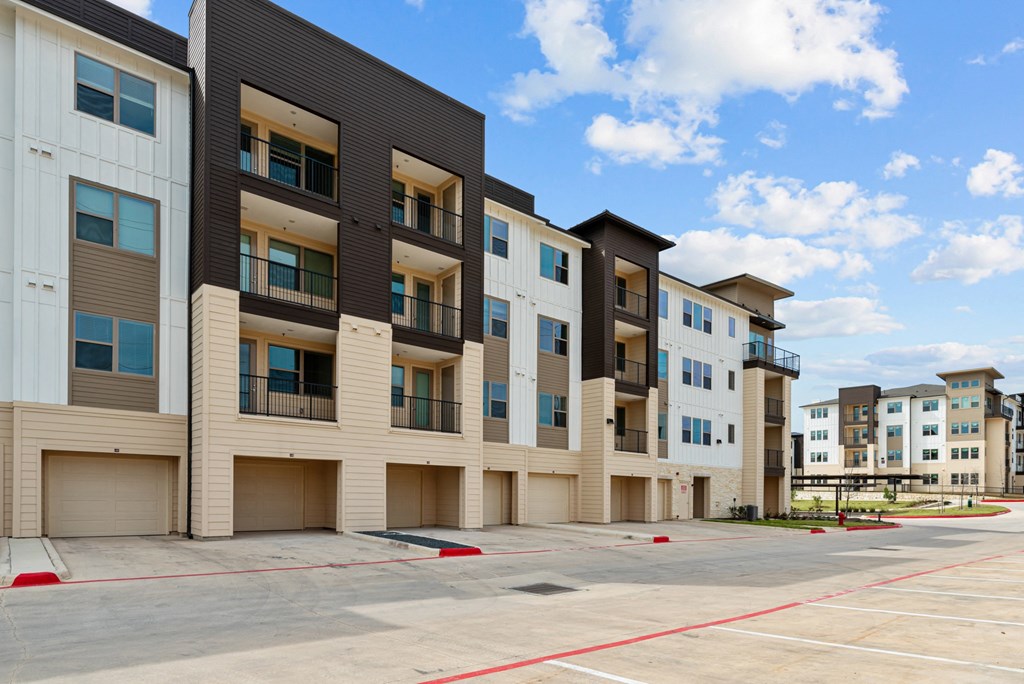 A row of modern apartment buildings with balconies and garages.