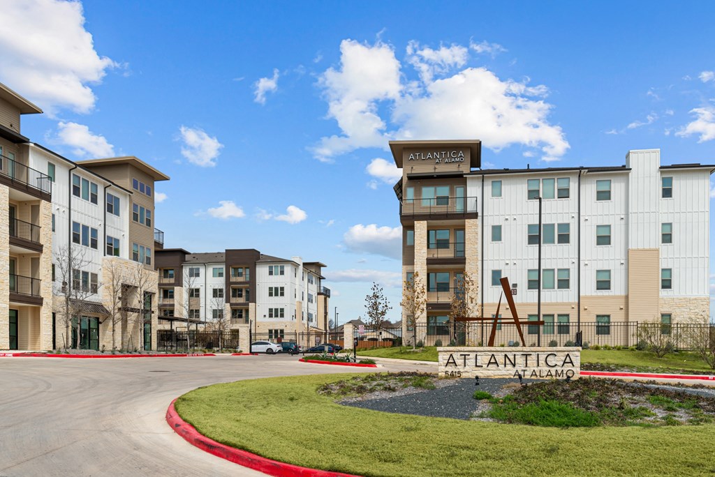 The image shows a multi-story building named Atlantica with a sign in front of it.