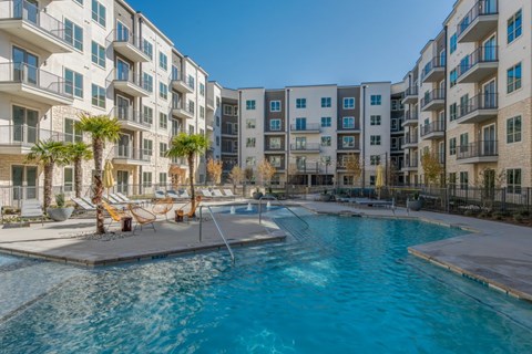 A swimming pool in front of apartment buildings.