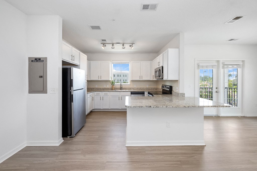 a kitchen with white cabinets and a large island with granite countertops