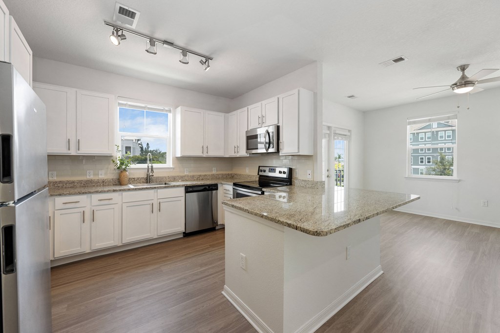 a kitchen with white cabinets and a granite counter top