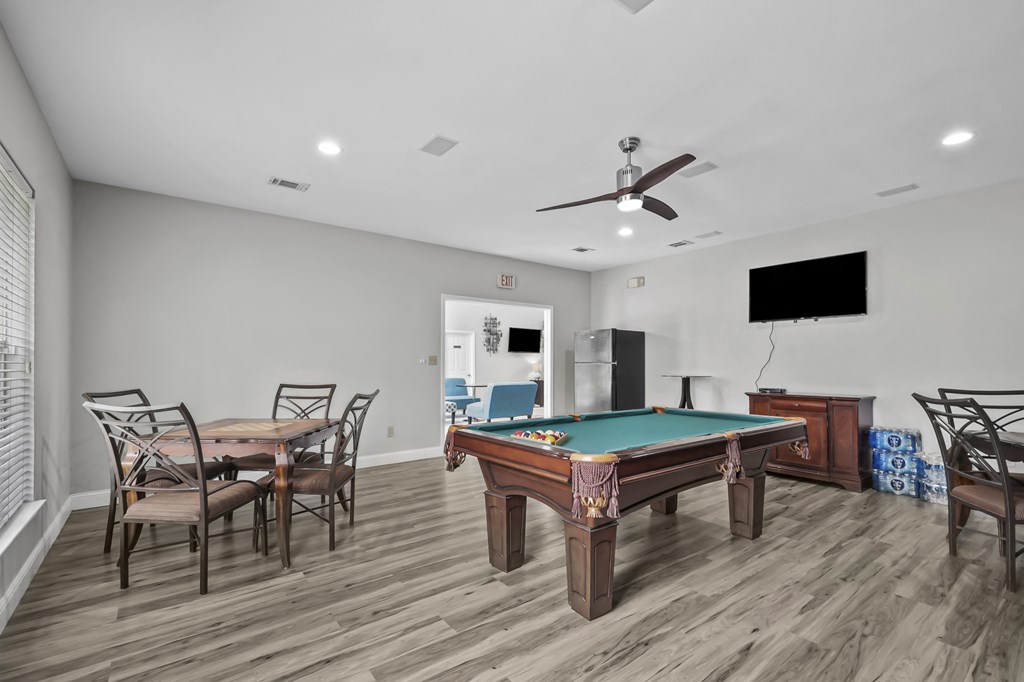 A room with a pool table and a television.