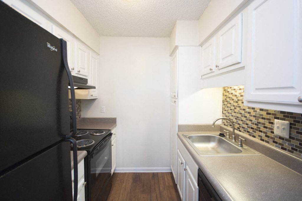 a kitchen with black appliances and white cabinets