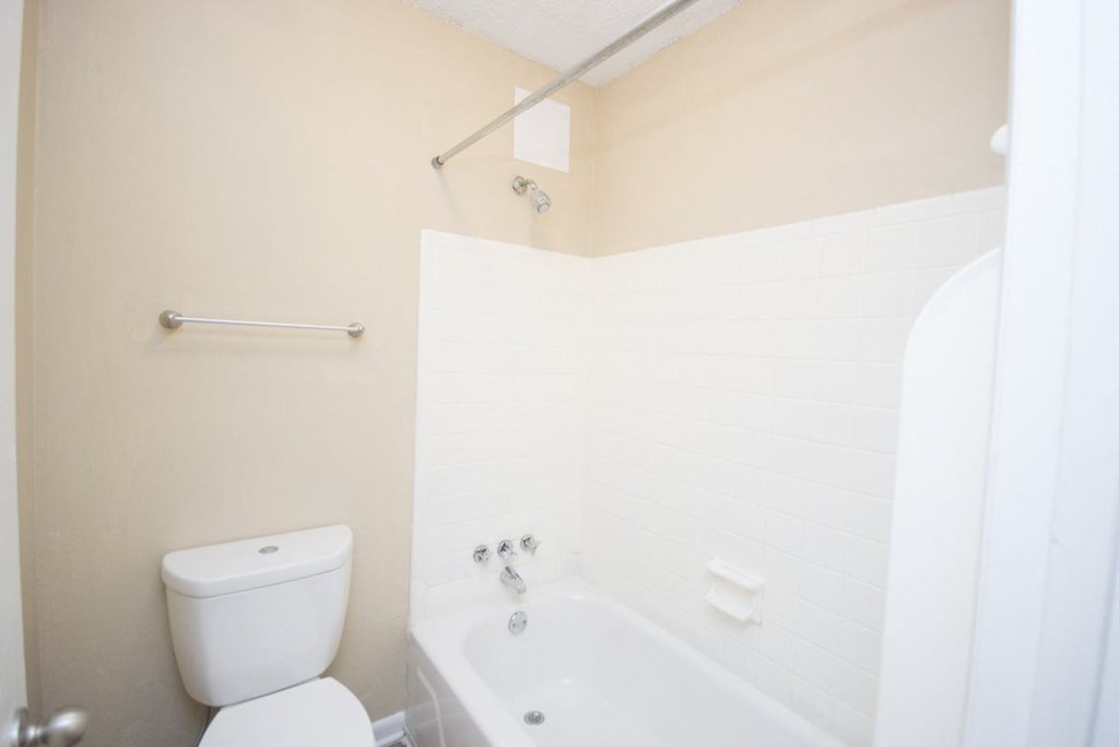 a white bathroom with a toilet and a sink