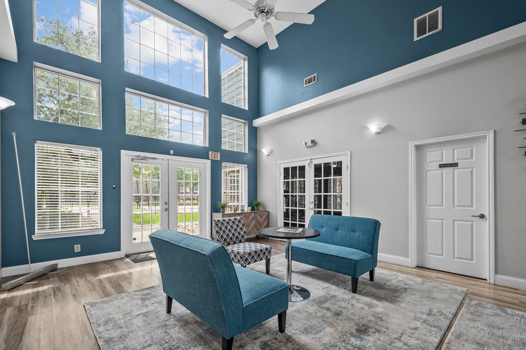 A blue chair and a blue sofa are in a room with a ceiling fan.