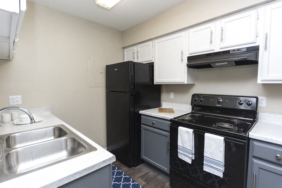 a kitchen with black appliances and white cabinets