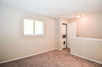 an empty room with a laundry room and a window