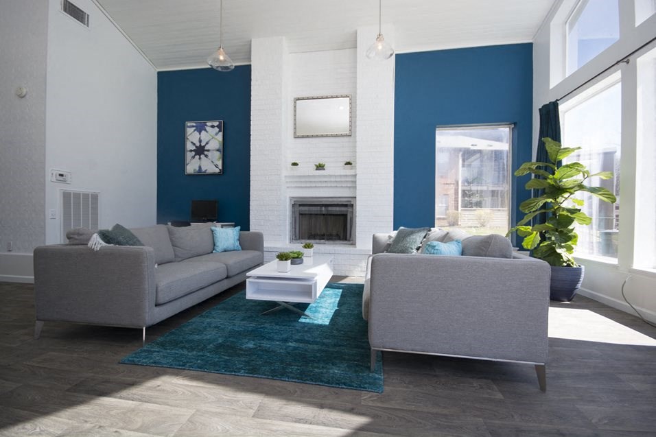 a living room with blue walls and white furniture