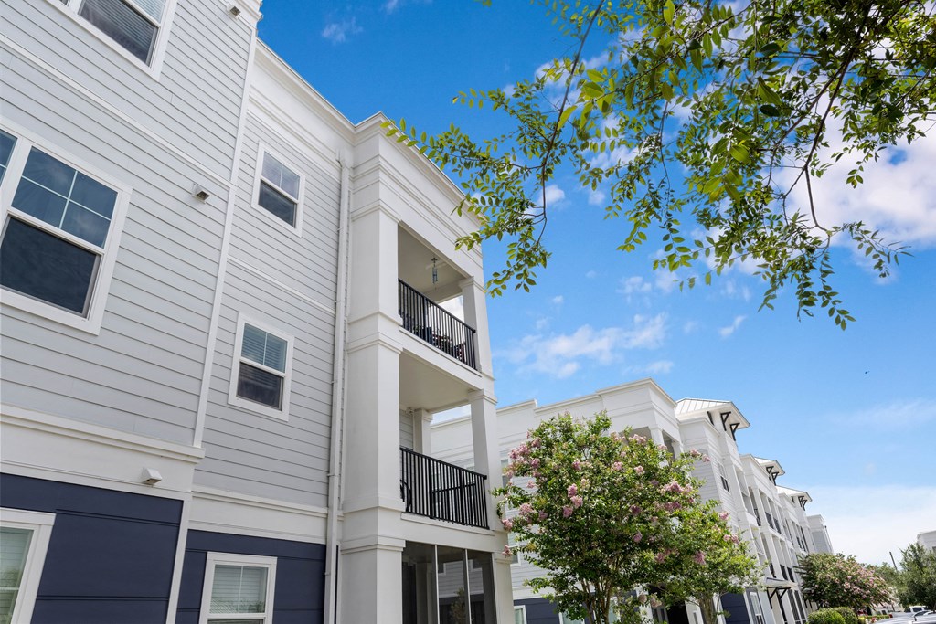 a picture of a white apartment building with a blue sky in the background