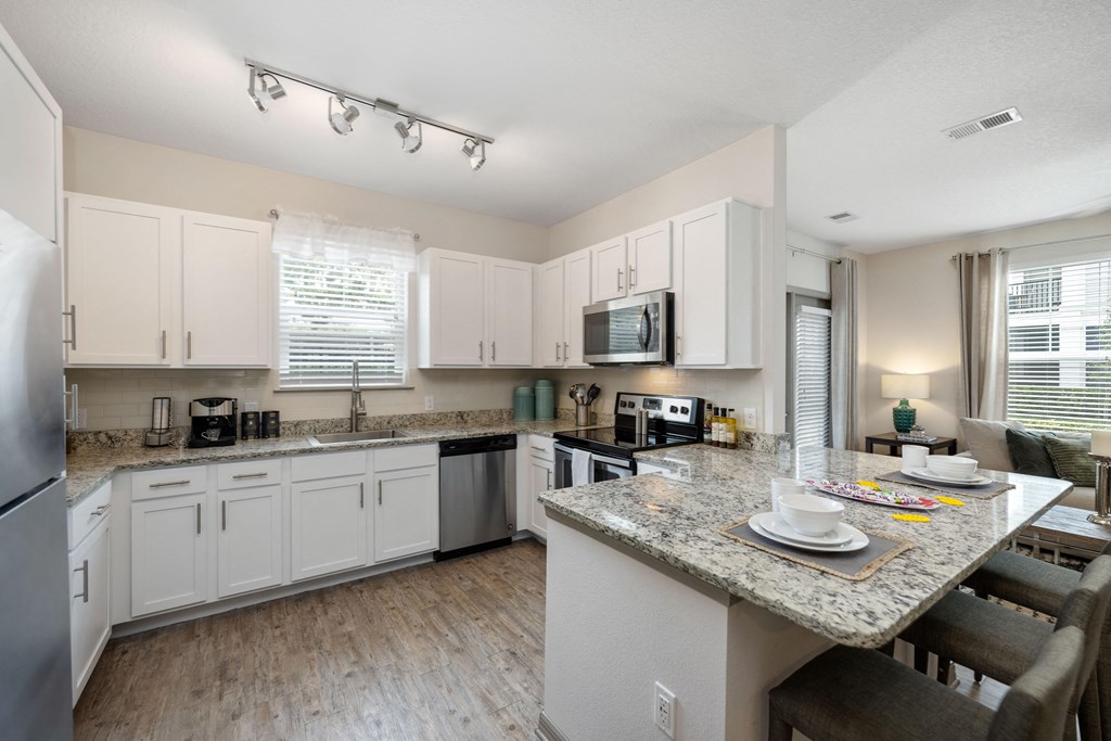 a kitchen with white cabinets and a granite counter top